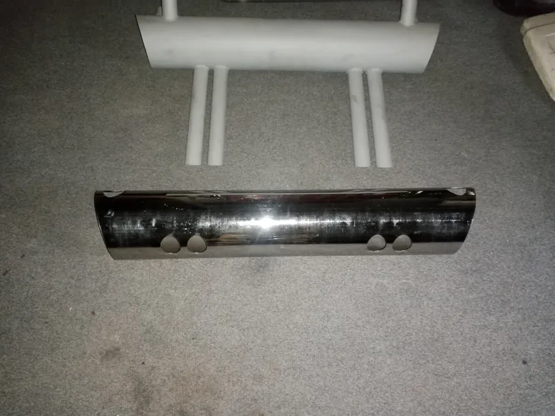 Chrome muffler shell positioned in front of a white exhaust assembly