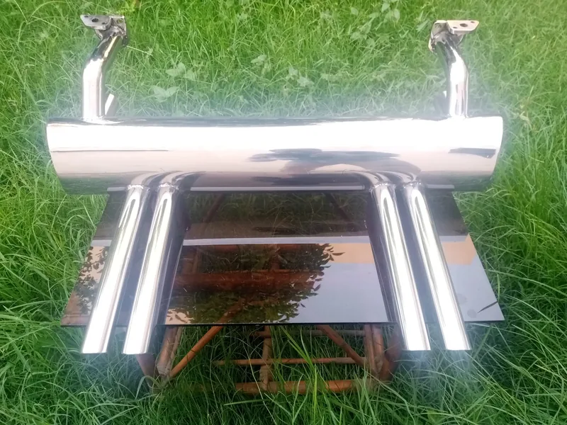 Chrome four-tip exhaust assembly displayed above grass