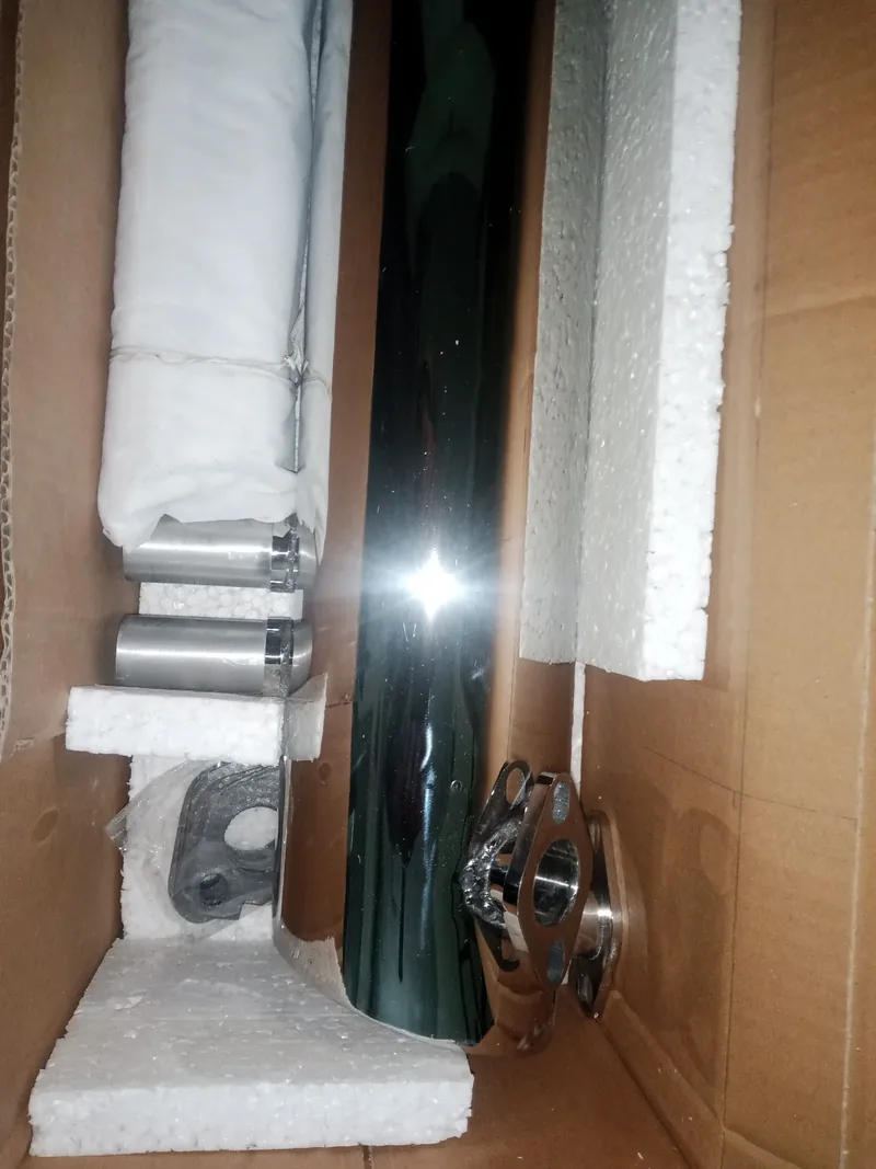 Side view of a chrome exhaust and fittings packed with foam inside a box