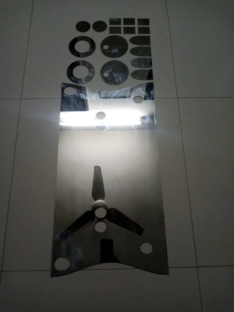 Shaped metal plates and circular cutouts arranged on a tiled floor