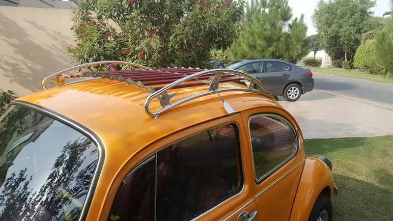 Chrome-and-red roof rack fitted to an orange Volkswagen Beetle viewed from above