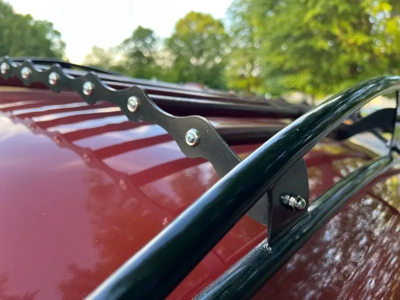 Scalloped slat support and black side rail on a red Volkswagen Beetle roof rack