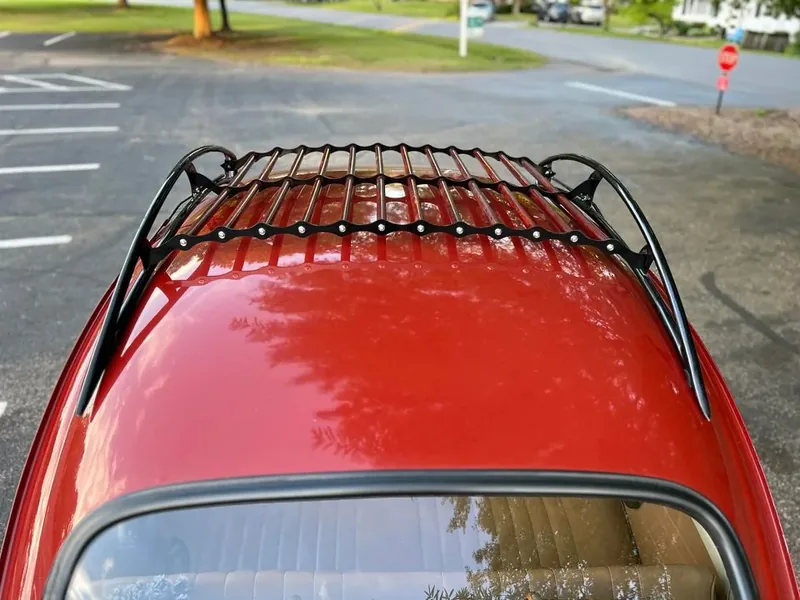 Black-and-red roof rack centered above the windshield of a red Volkswagen Beetle