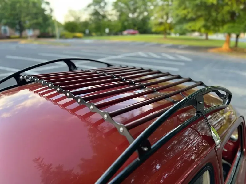 Angled close-up of a black roof-rack frame and red slats on a red Volkswagen Beetle