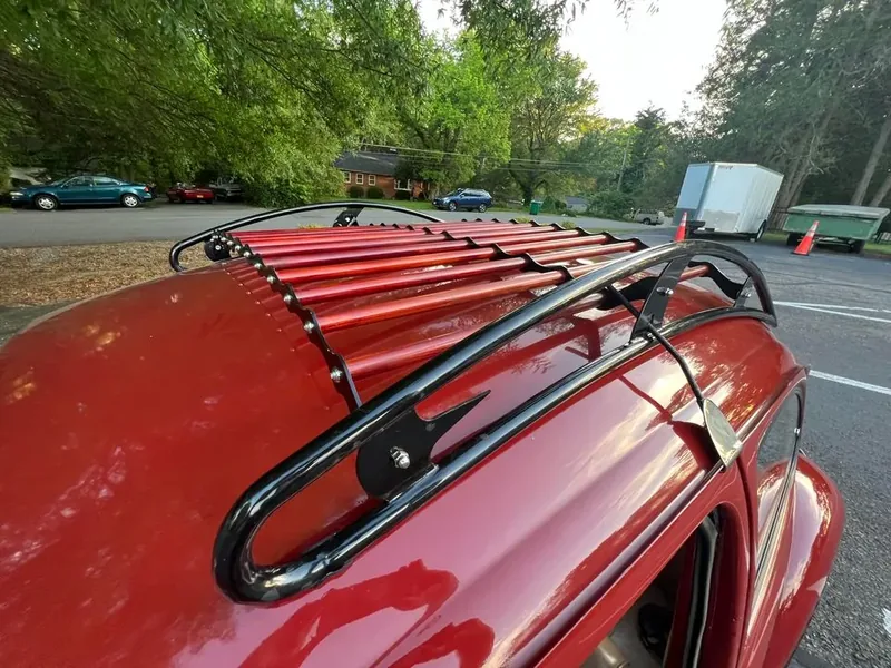 Black-and-red roof rack viewed diagonally across a red Volkswagen Beetle roof