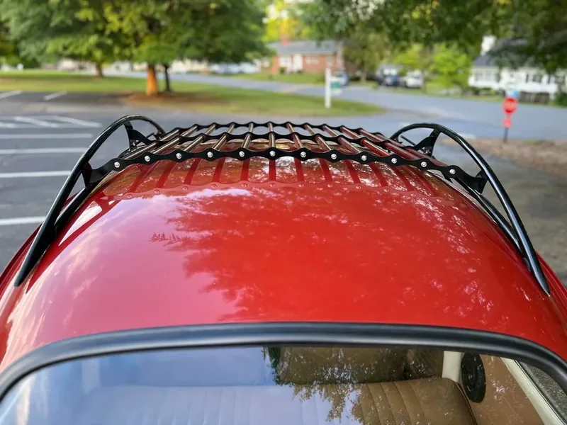 Black-and-red roof rack centered above a red Volkswagen Beetle rear window