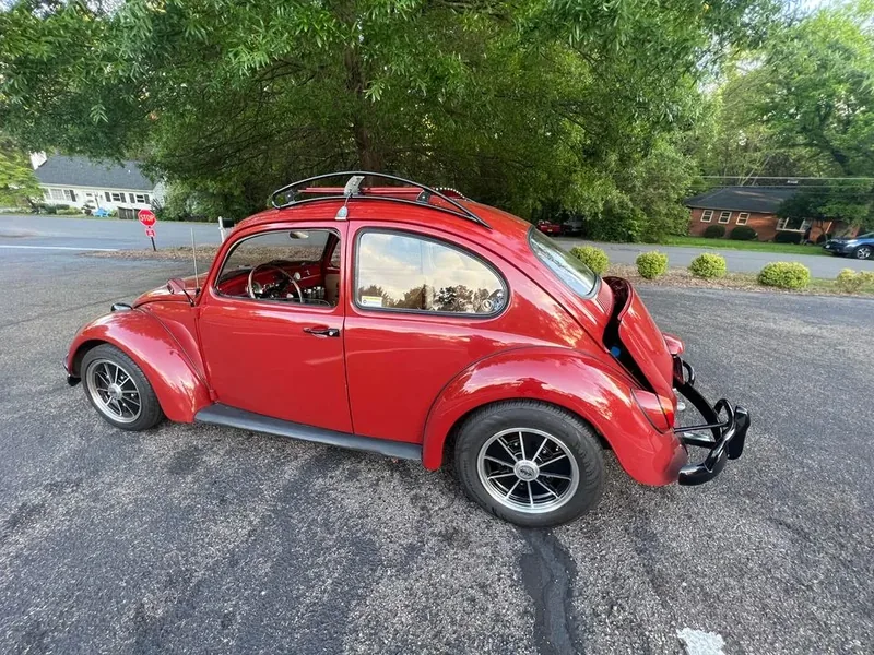 Rear three-quarter view of a red Volkswagen Beetle with a fitted roof rack
