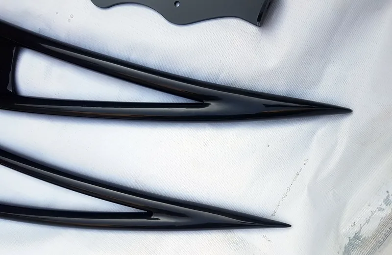 Loose pointed black roof-rack side rails on a white surface