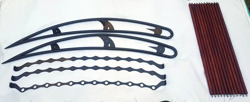 Black frame rails, scalloped supports and reddish-brown slats laid out separately
