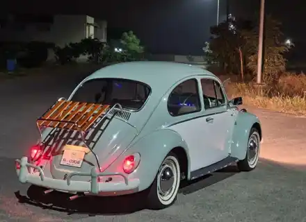 White VW Beetle with deck-lid rack fitted at night