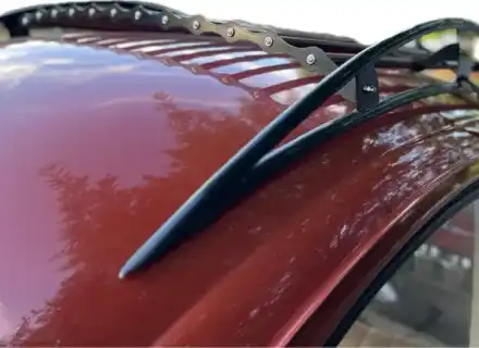 Barres de toit noires et bandes de lattes festonnées montées sur une Volkswagen Beetle rouge